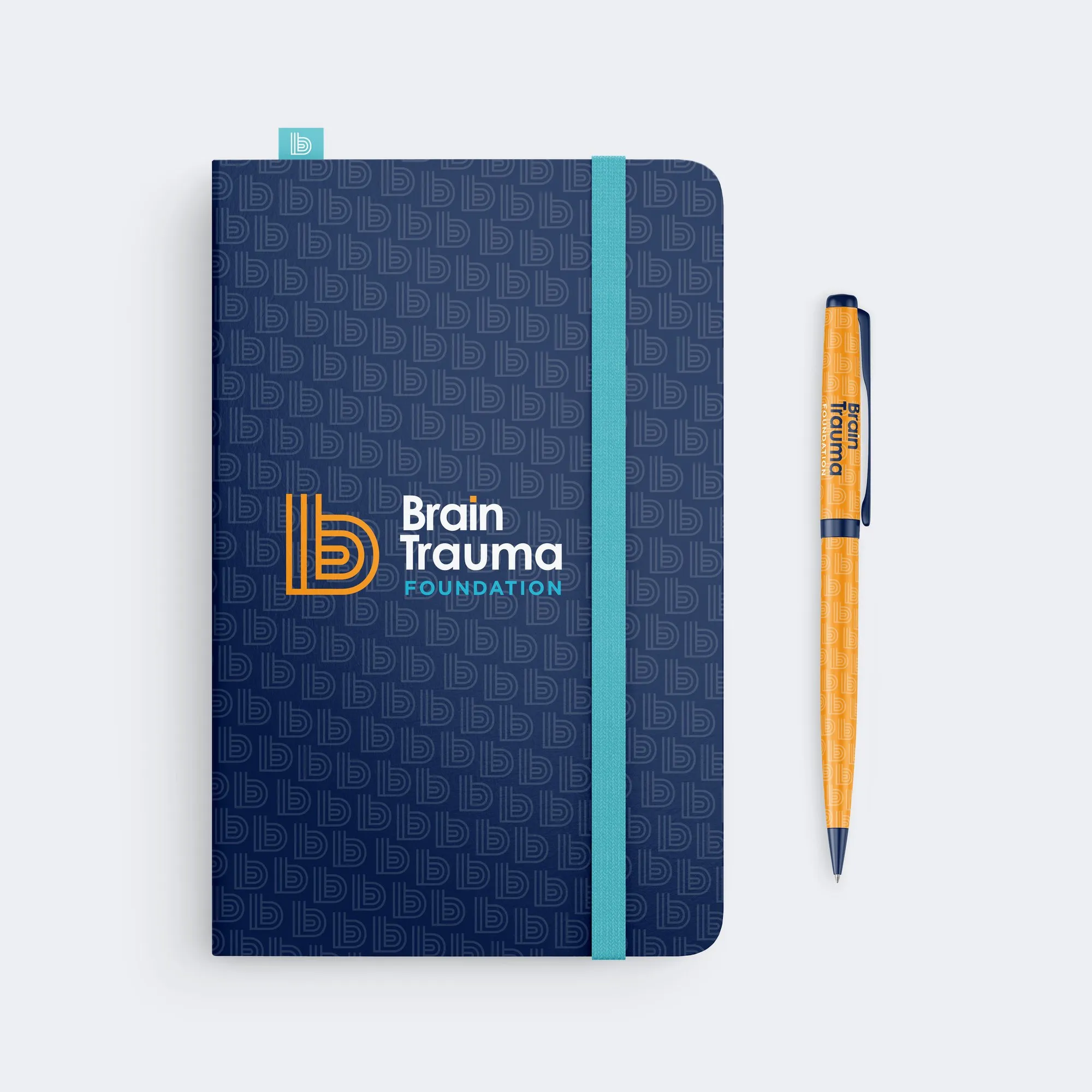 A navy notebook covered in a tone-on-tone b pattern, with an orange pen