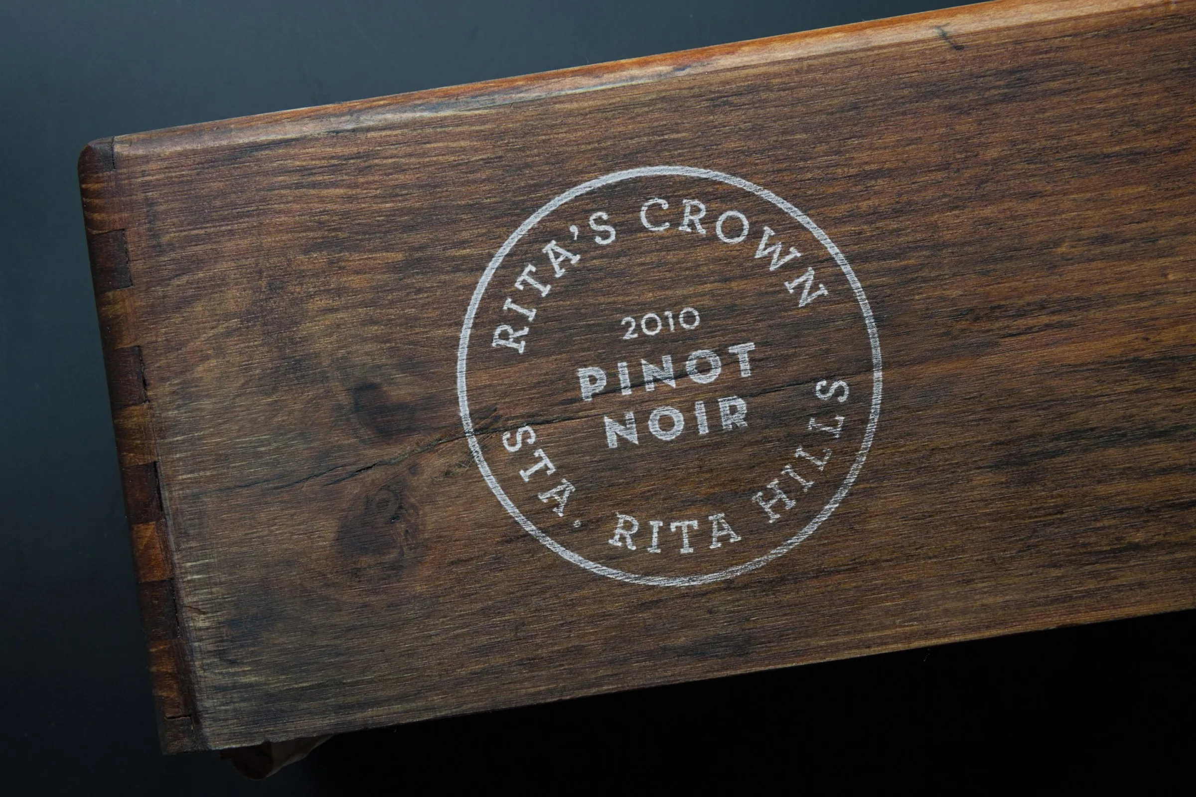 The Rita’s Crown Pinot Noir stamp branded into a wooden wine crate