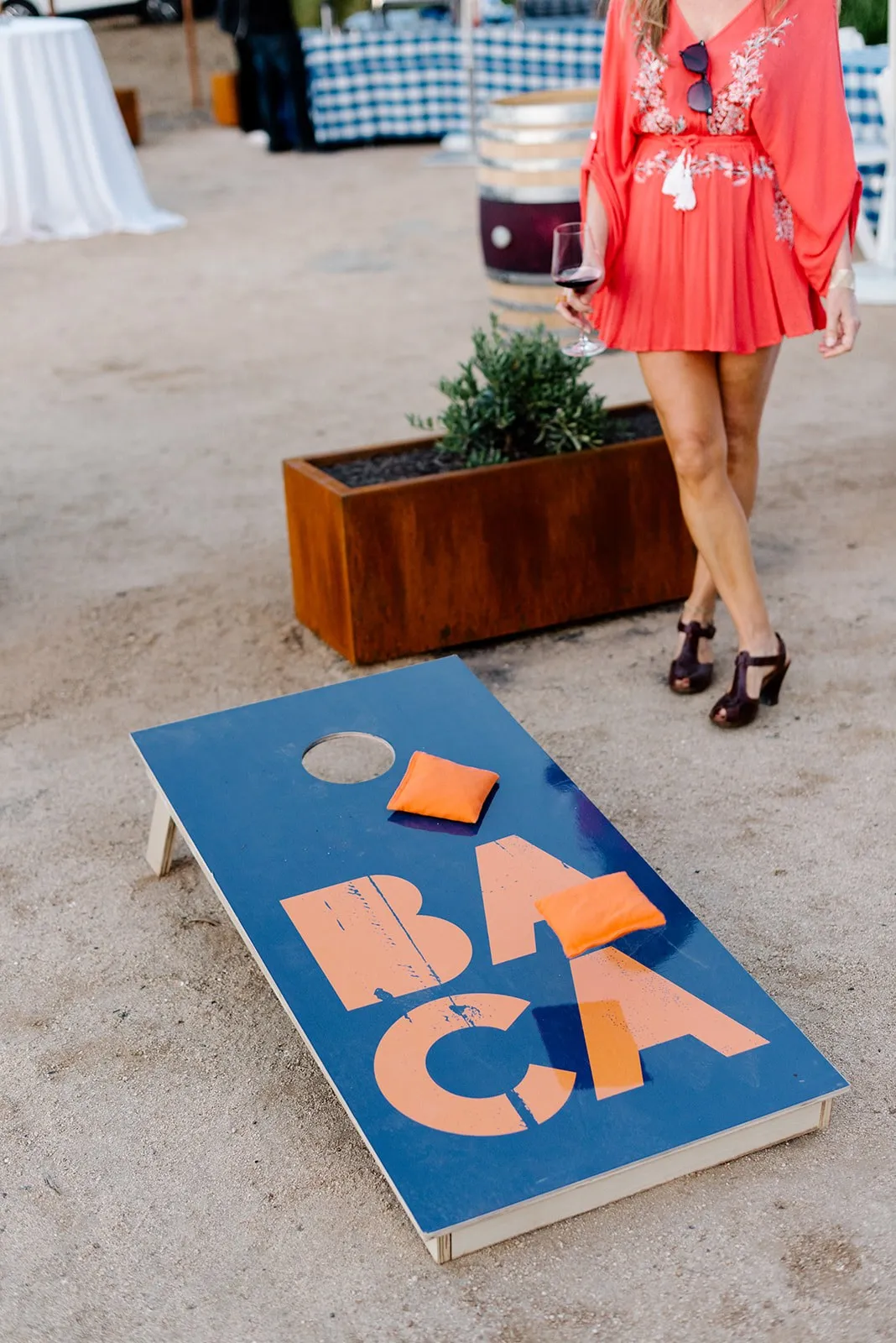 A blue and orange BACA cornhole board on the lawn